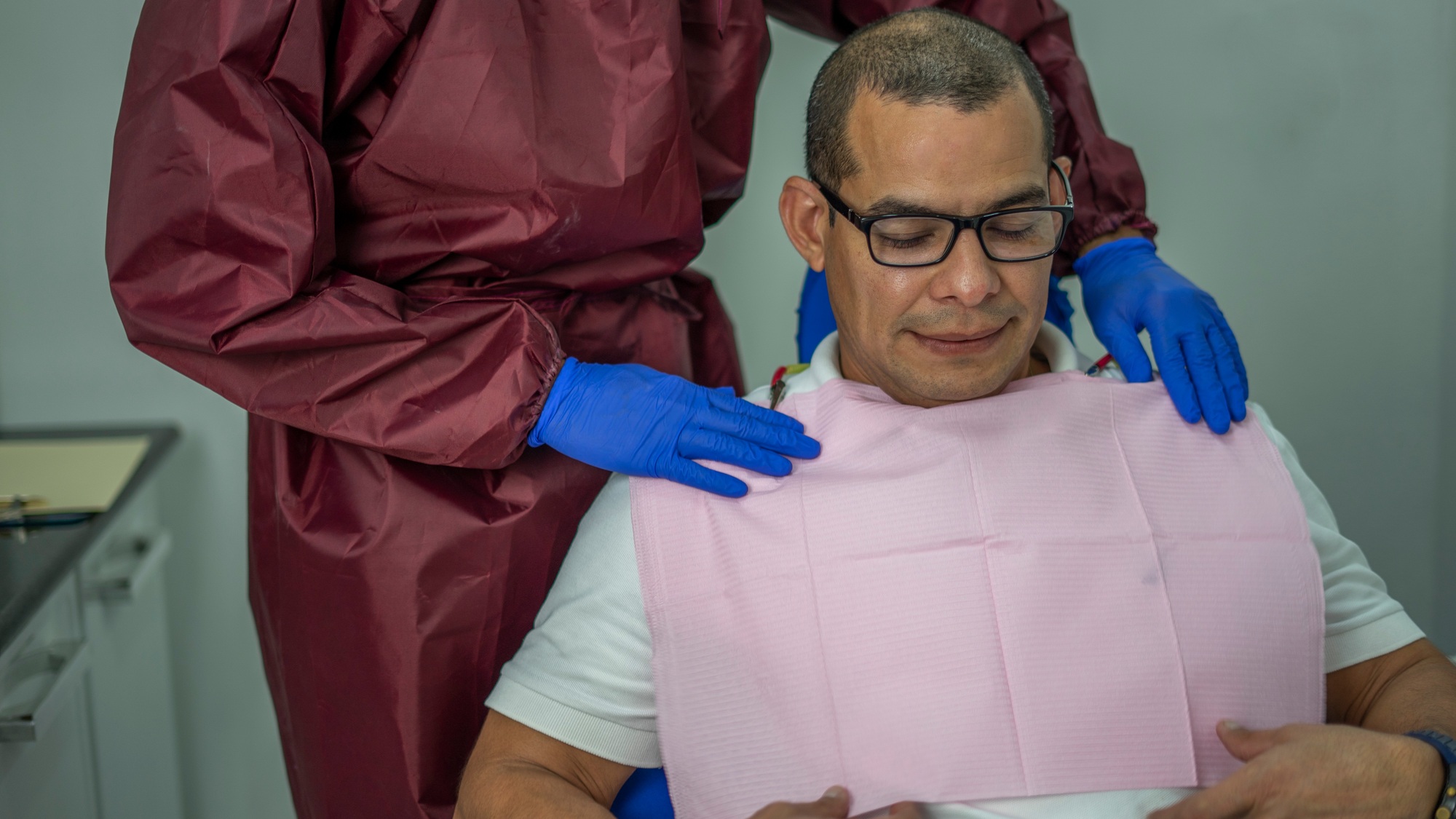Middle-aged Hispanic patient being prepared for a dental intervention
