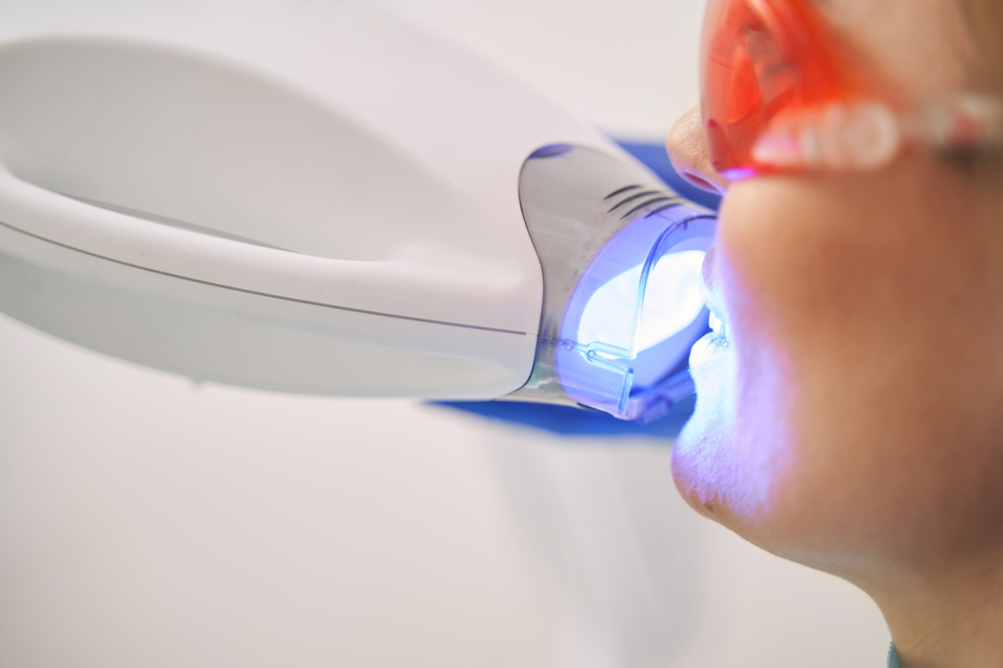 Woman receiving dental treatment with laser device